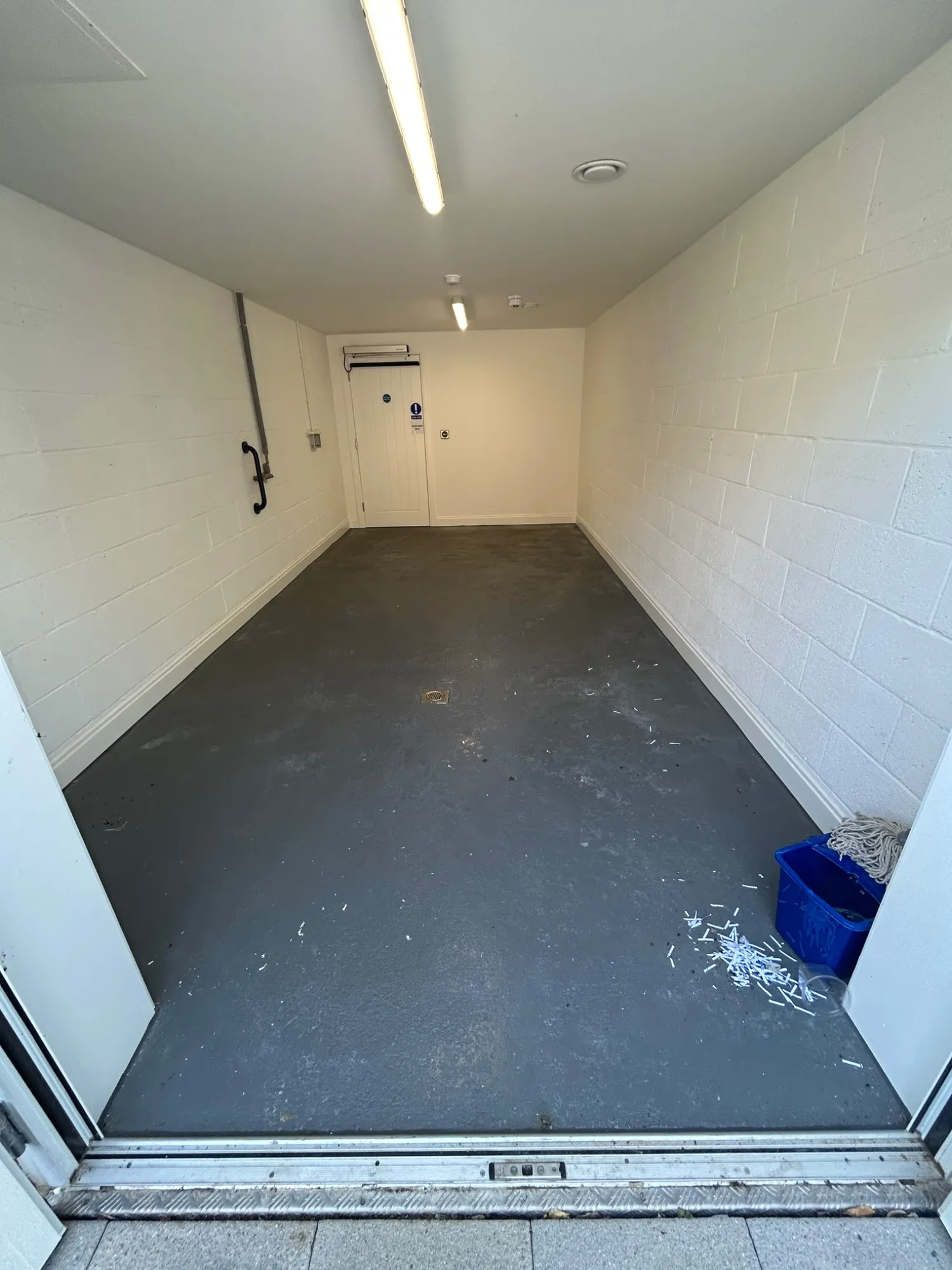 Empty bin store in Rickmansworth before the deep clean, with debris across the floor